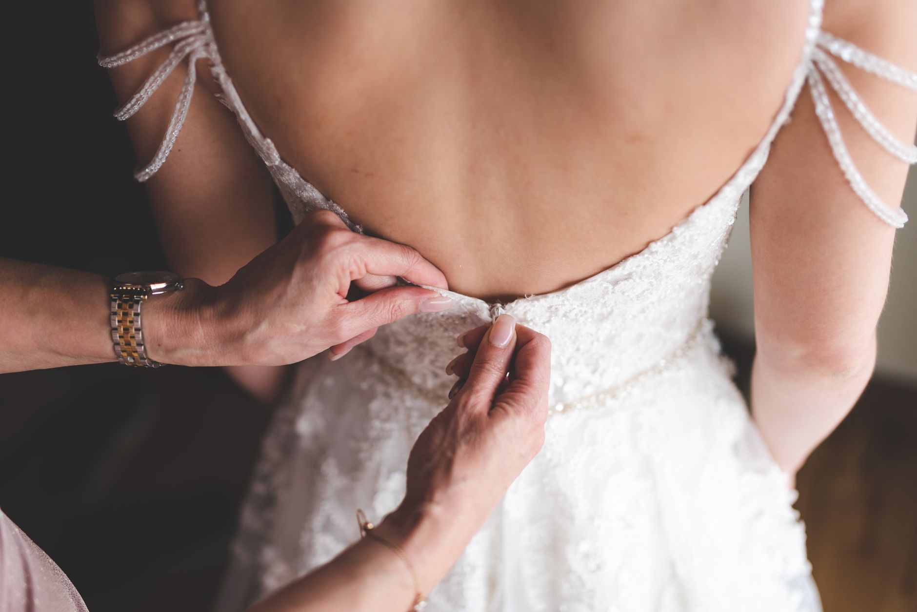Hände richten ein Brautkleid